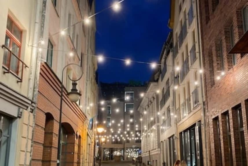 Oryginalne płyty chodnikowe a nad nimi świetlista girlanda Oryginalne płyty chodnikowe a nad nimi świetlista girlanda