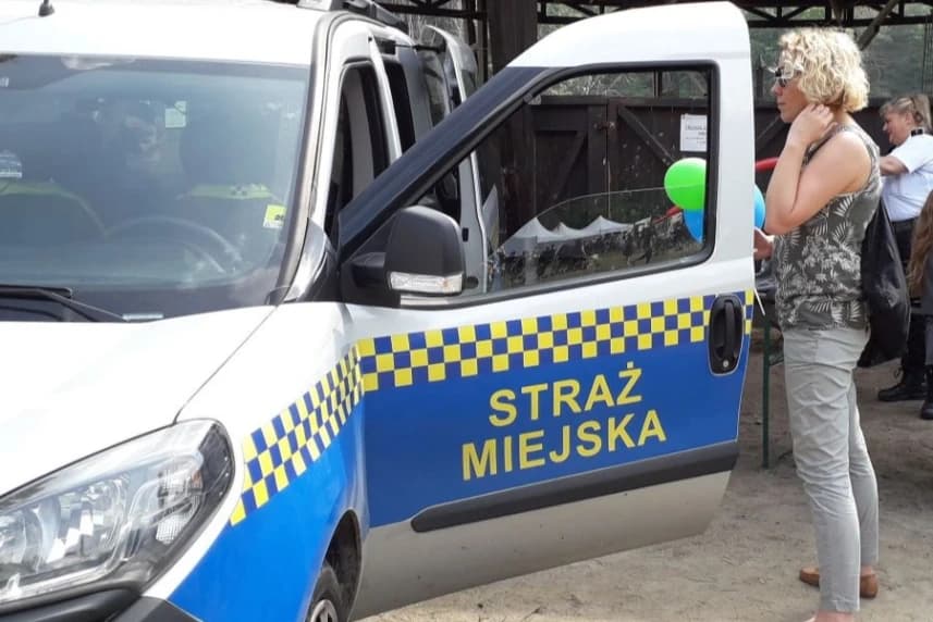 Żagle 2025. Plan zabezpieczenia imprezy przez Straż Miejską Szczecin Kobieta stojąca przy samochodzie straży miejskiej.