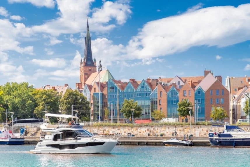 Szczecin przyciąga turystów Jacht płynący Odrą, na tle panoramy Szczecina.