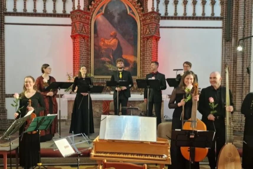 Koncert pasyjny Fundacji Akademia Muzyki Dawnej Grupa muzyków na tle ołtarza w kościele.