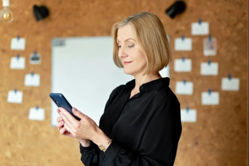 ZDiTM: Nowy system zakupu i aktywacji biletów wejdzie w życie od lipca Kobieta ubrana w czarną bluzkę trzyma w dłoniach telefon komórkowy.