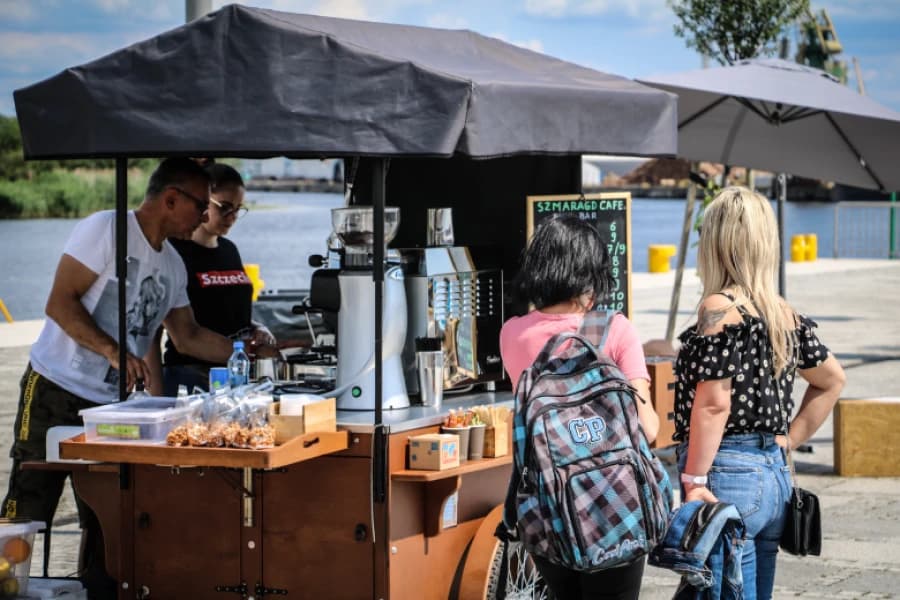 Dołącz do grona wystawców Food Portu Z prawej dwie dziewczyny stojące przy punkcie gastronomicznym na Łasztowni.