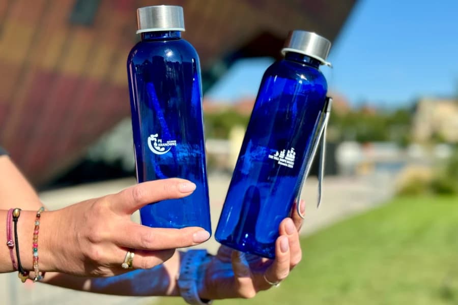 Światowe Dnia Ziemi. Zachęcamy mieszkańców, ale zaczynamy od siebie Dwie granatowe butelki z woda trzymane w dłoniach.