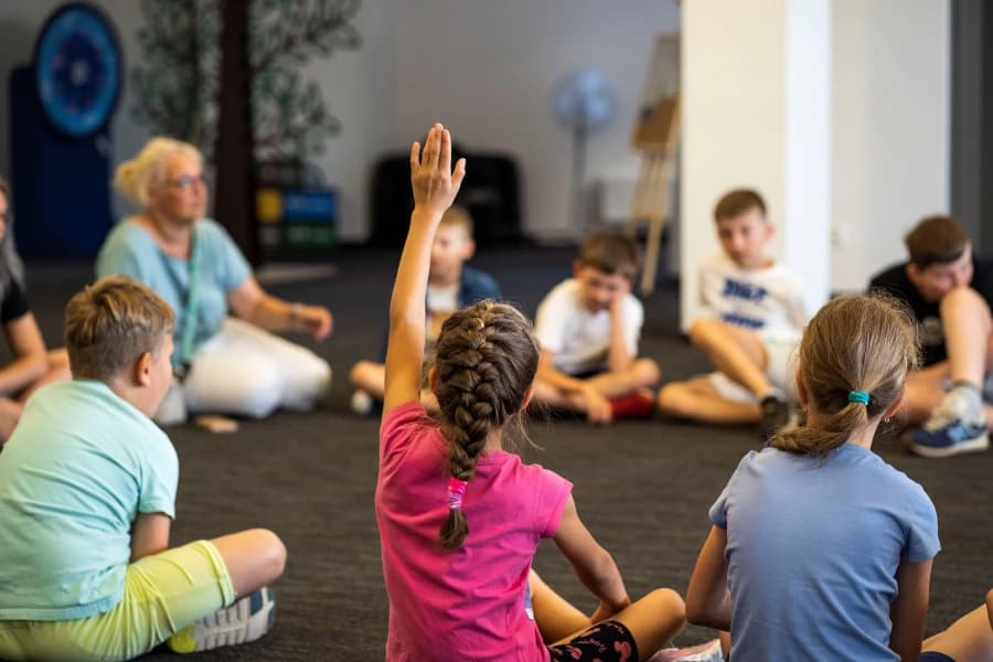 Spędź lato z Enea Areną! Rusza nabór na letnie półkolonie Grupa dzieci siedzących na podłodze.