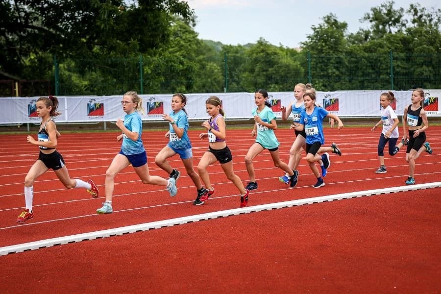 Młodzi lekkoatleci na start! Zapraszamy na 1. POLSCA Athletics – Mityng Otwarcia Sezonu Grupa młodych sportowców w czasie biegu.