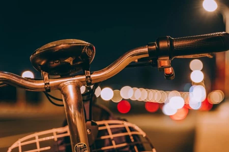 Nowa droga rowerowa na ul. Struga w Szczecinie. ZDiTM ogłasza przetarg Kierownica rowerowa na tle oświetlonej wieczorem ulicy.