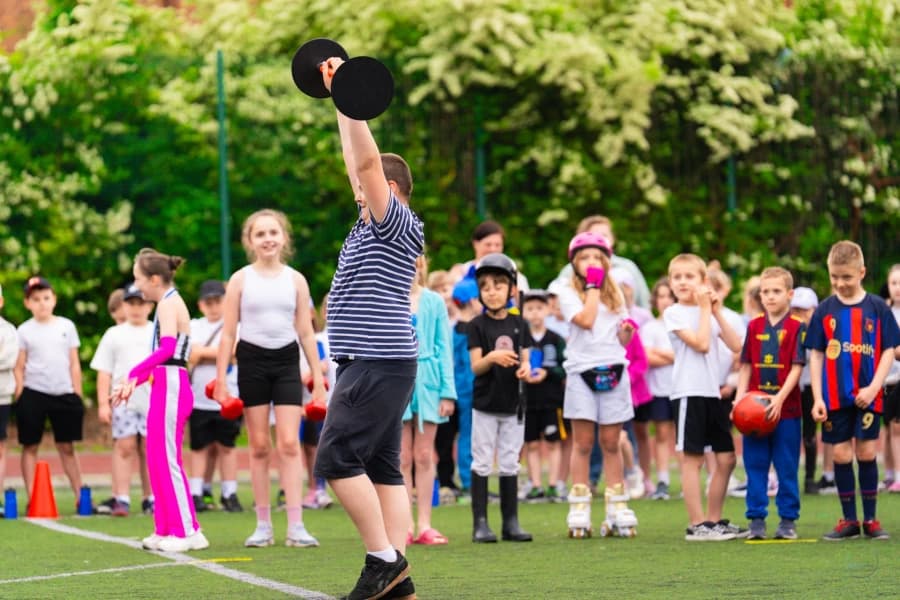 Sportowy Dzień Dziecka w SP 18. Setki spalonych kalorii i mnóstwo dobrej energii Grupa dzieci na boisku sportowym.