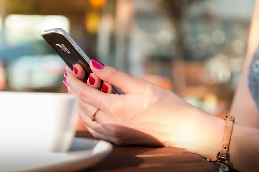 Od 1 lipca kupisz bilet jednorazowy w aplikacji z wyprzedzeniem Telefon trzymany w damskich dłoniach.