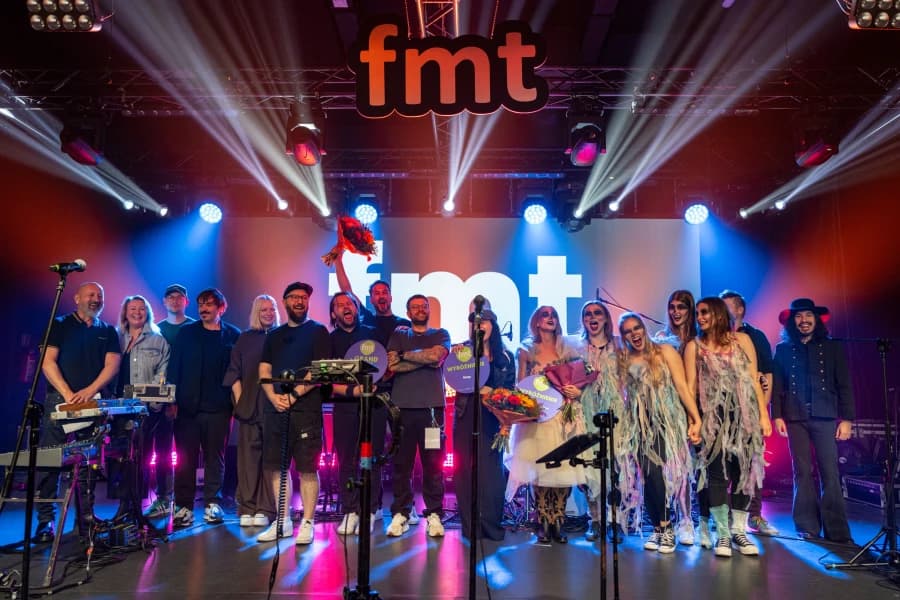 Grupa ludzi na scenie Festiwalu Młodych Talentów.